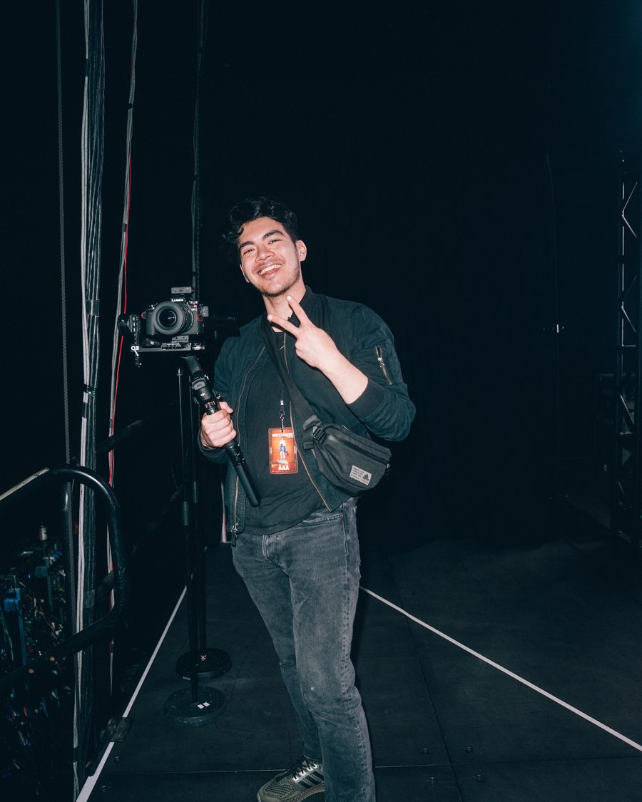 Charles backstage with a camera rig and tour pass