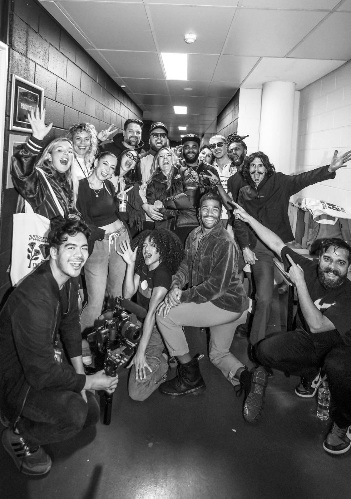 Black and white photo of the BEN Tour crew backstage, with Charles in the group